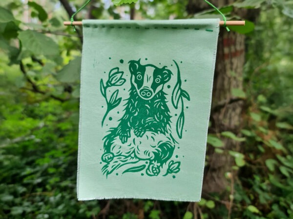 Grüner Stoffbanner mit aufgedrucktem Dachs, Blumen und Blättern