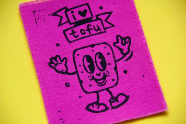 Pinker Aufnäher mit aufgedrucktem Comic-Tofu und dem Spruch "I Love Tofu" in Schwarz