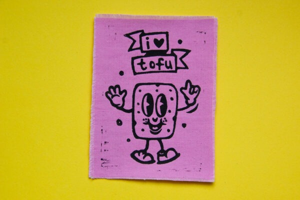 Rosa Aufnäher mit aufgedrucktem Comic-Tofu und dem Spruch "I Love Tofu" in Schwarz