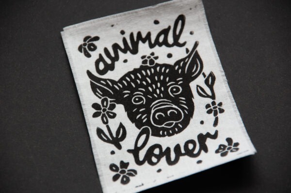 Weißer Patch mit schwarzem Aufdruck eines Schweins und dem Schriftzug "animal lover"