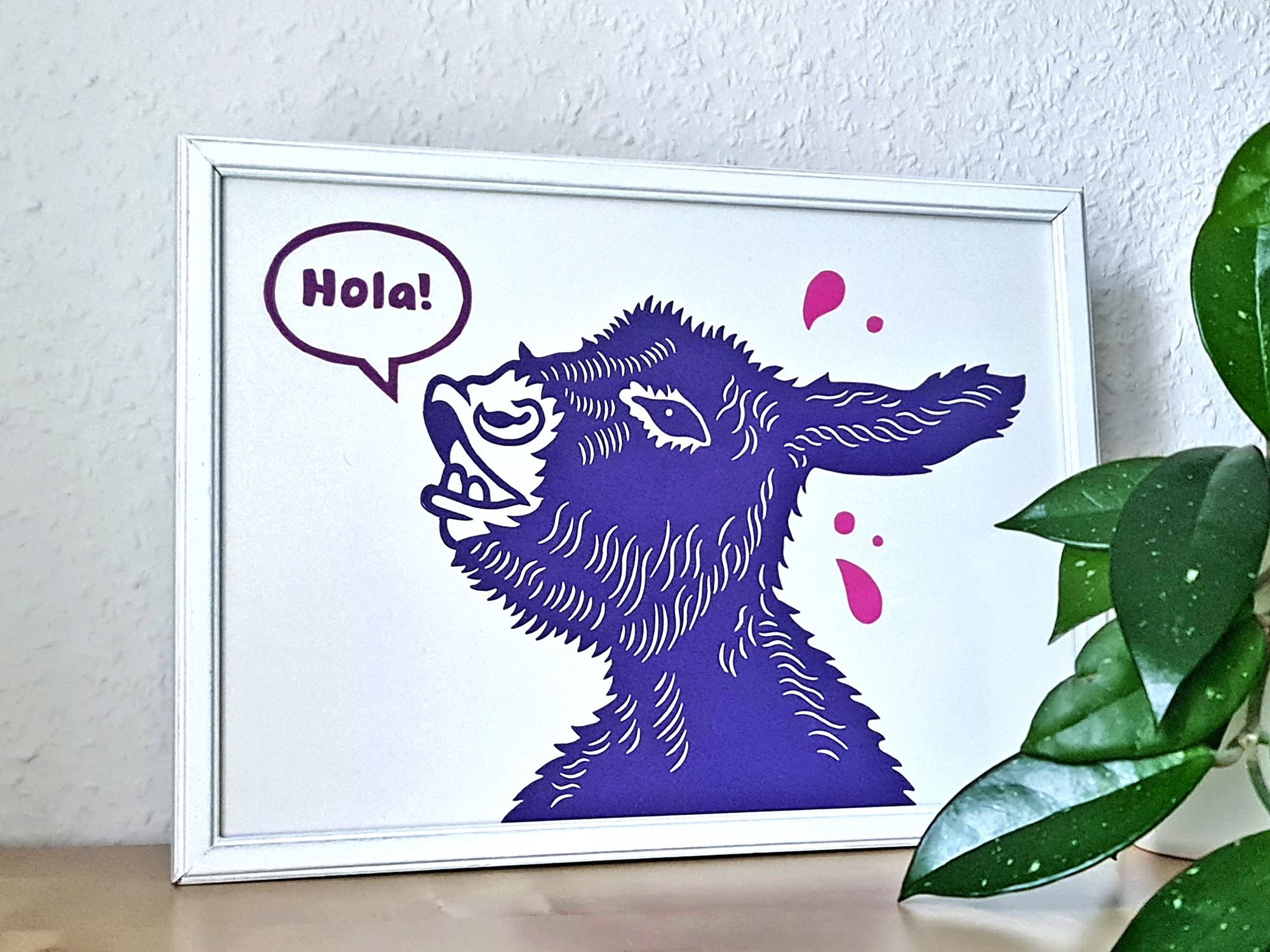 Handgemachter Linoldruck als Wandbild mit einem lila Esel und einer Sprechblase mit dem Text „Hola!“ mit pinken Tropfen auf weißem Hintergund
