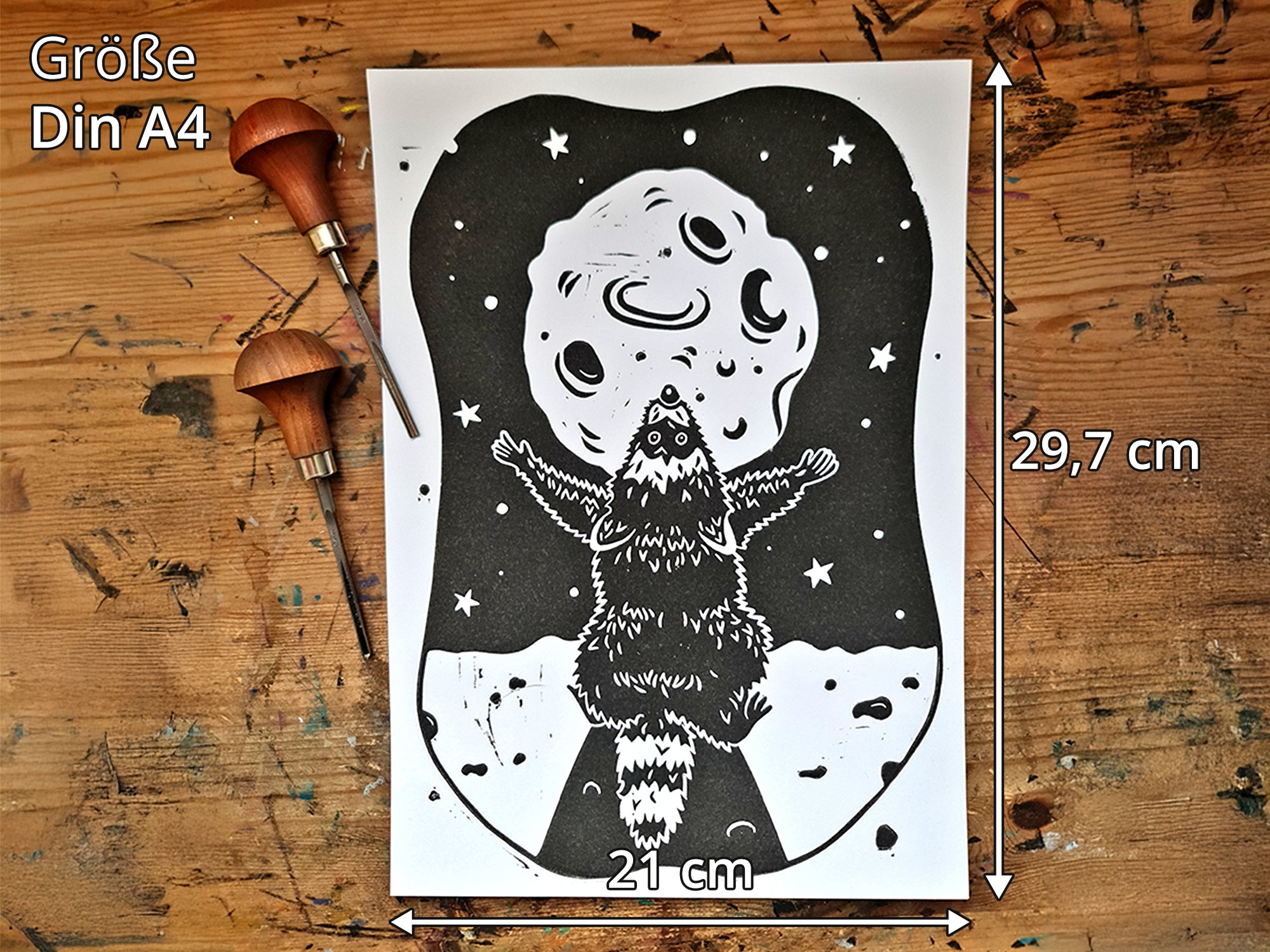 Ein Linoldruck mit einem schwarzen Waschbären, der den Mond anbetet auf einer Holzfläche
